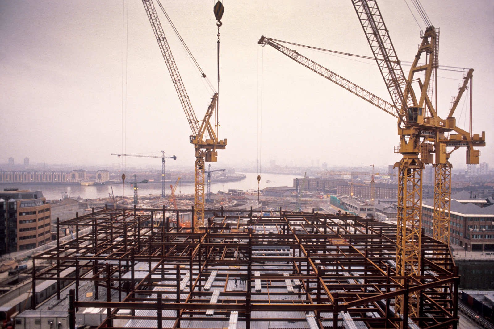 After the old Canary Wharf was demolished, cranes can be seen across the Docklands in its process of redevelopment, seen in the foreground the building of the basic structure which would become Canada Square, London, UK