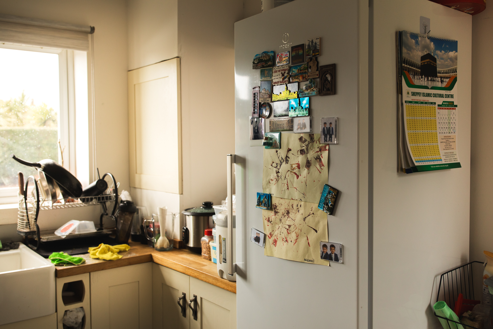 The Islam family kitchen, with a calendar from the local mosque and artwork by the photographer’s nephews.