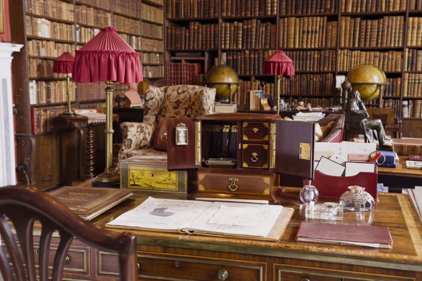 The Library at Kingston Lacy, Dorset, with the pair of Regency terrestrial and celestial globes made by Smith's. The top of the Regency rosewood writing-table in the manner of John McLean & Son, a London firm of cabinetmakers, is in the foreground.