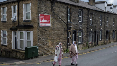 Two women walk past a sign encouraging people to vote for the Labour Party in the forthcoming general election in the town centre of Keighley, northwest England, on June 14, 2024. Gaza is a long way from the picturesque foothills of the Yorkshire Dales but the issue could swing UK general election races in northern England, with many local Muslims angry at Labour's stance. While Labour is expected to win a thumping national majority on July 4, leader Keir Starmer's refusal to back an unconditional ceasefire in Gaza has caused a split with once-loyal Muslim supporters.