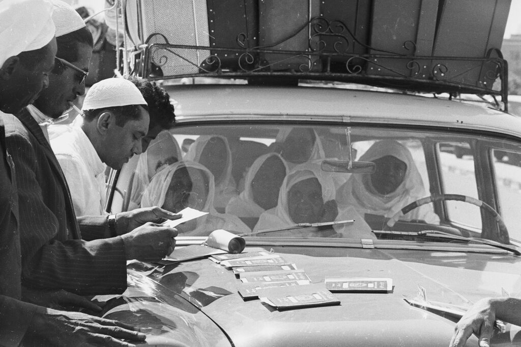 19th August 1968: Muslim pilgrims taking part in the Hajj pilgrimage checking their passports in Mecca.