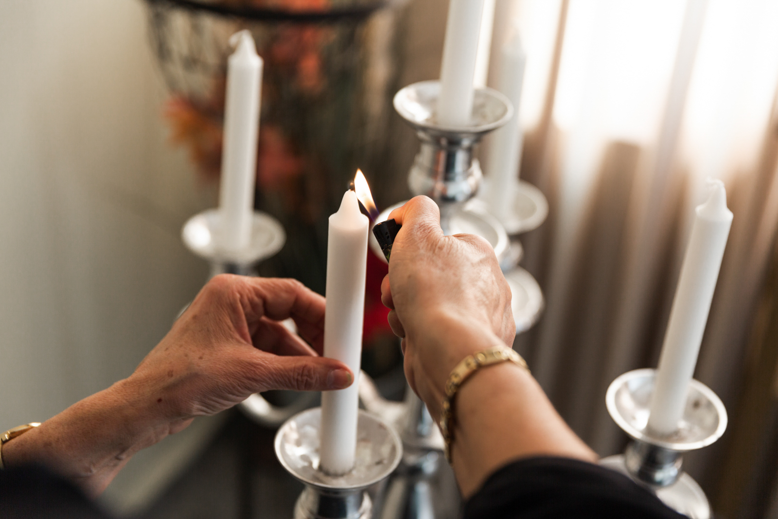 A woman lights up candles in memory of her late mother-in-law in the community room of Uludag Cenaze in Hamburg.