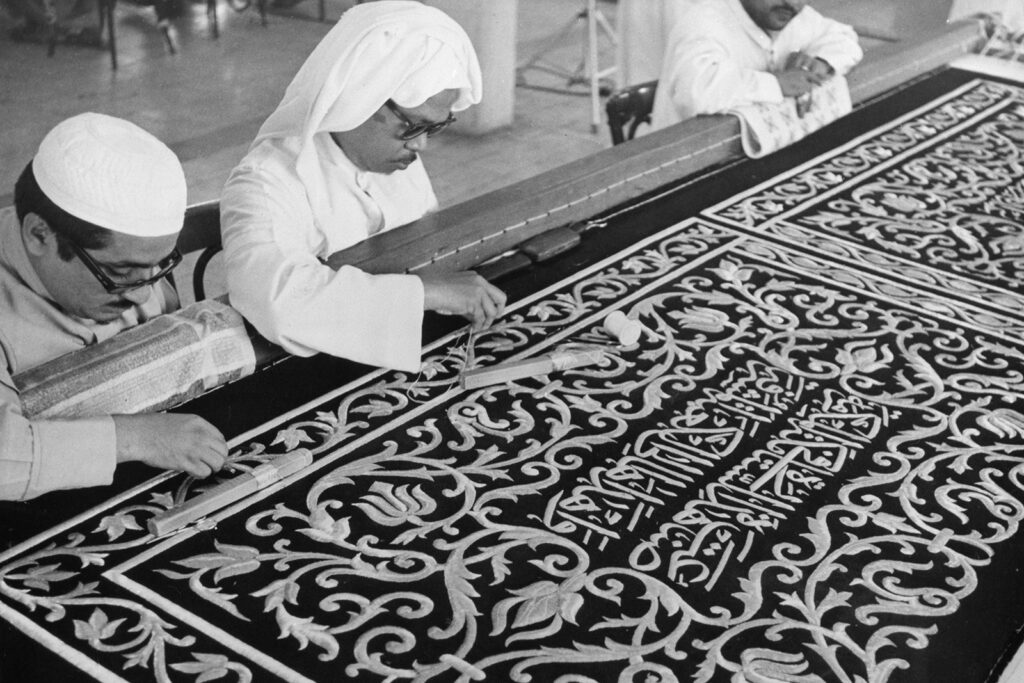 Saudi craftsmen embroidering fabric at a government factory in Mecca, Mecca Province, Saudi Arabia, 1976. Over 100 craftspeople weave over 2500ft of material on handlooms, which is then embroidered with Koran verses in preparation for the Hajj, an annual Islamic pilgrimage to Mecca, Islam's holiest city.