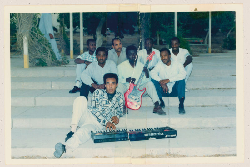 The band Stars of Africa pose on some steps with a keyboard and guitar