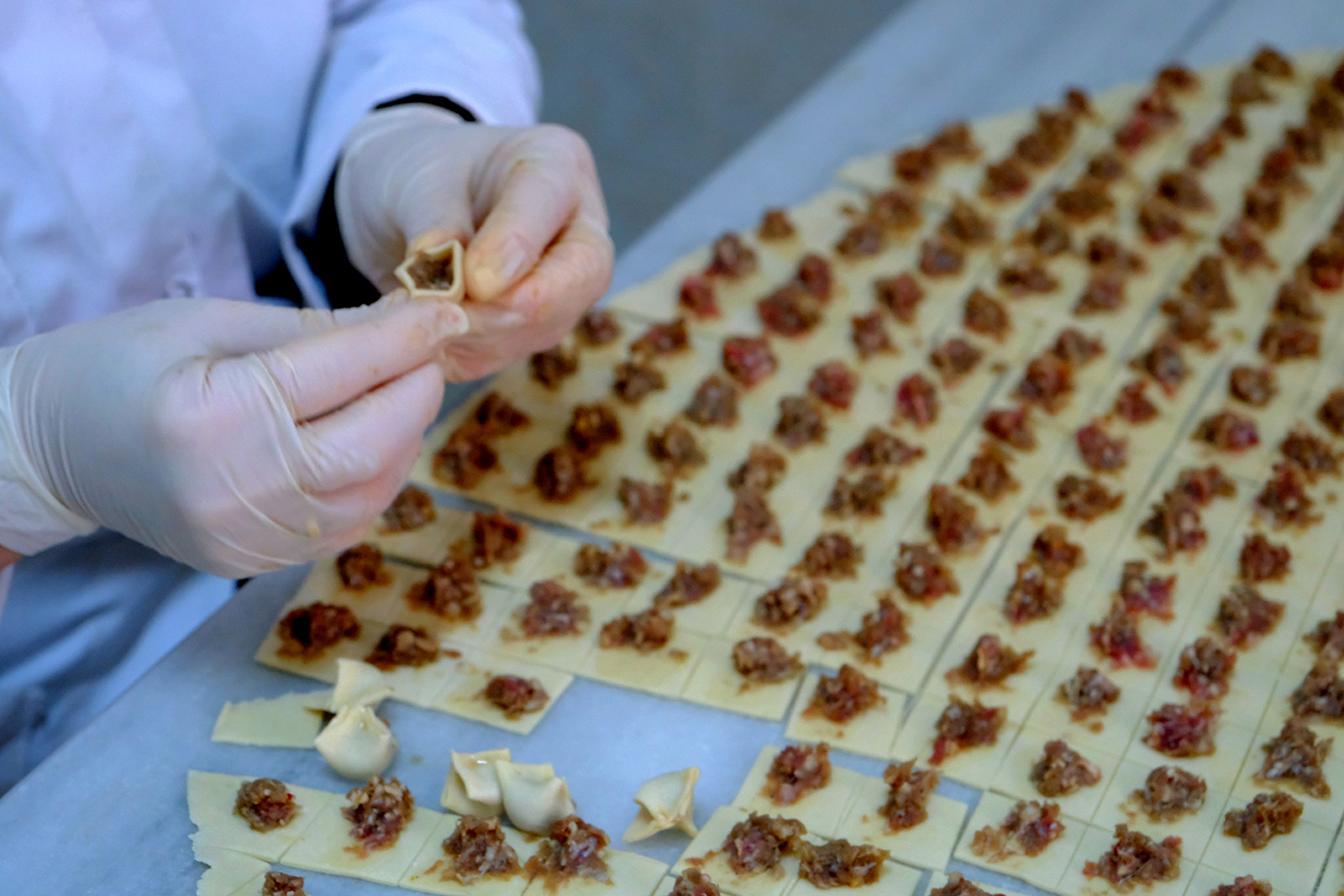 Making manti dumplings, a central Asian cuisine staple made with minced meat placed on thin dough.