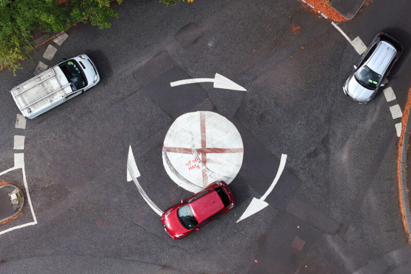 The flag of St George painted on to a mini traffic island and overwritten with 'Stop Hate' in Sale, Greater Manchester, in August 2025.