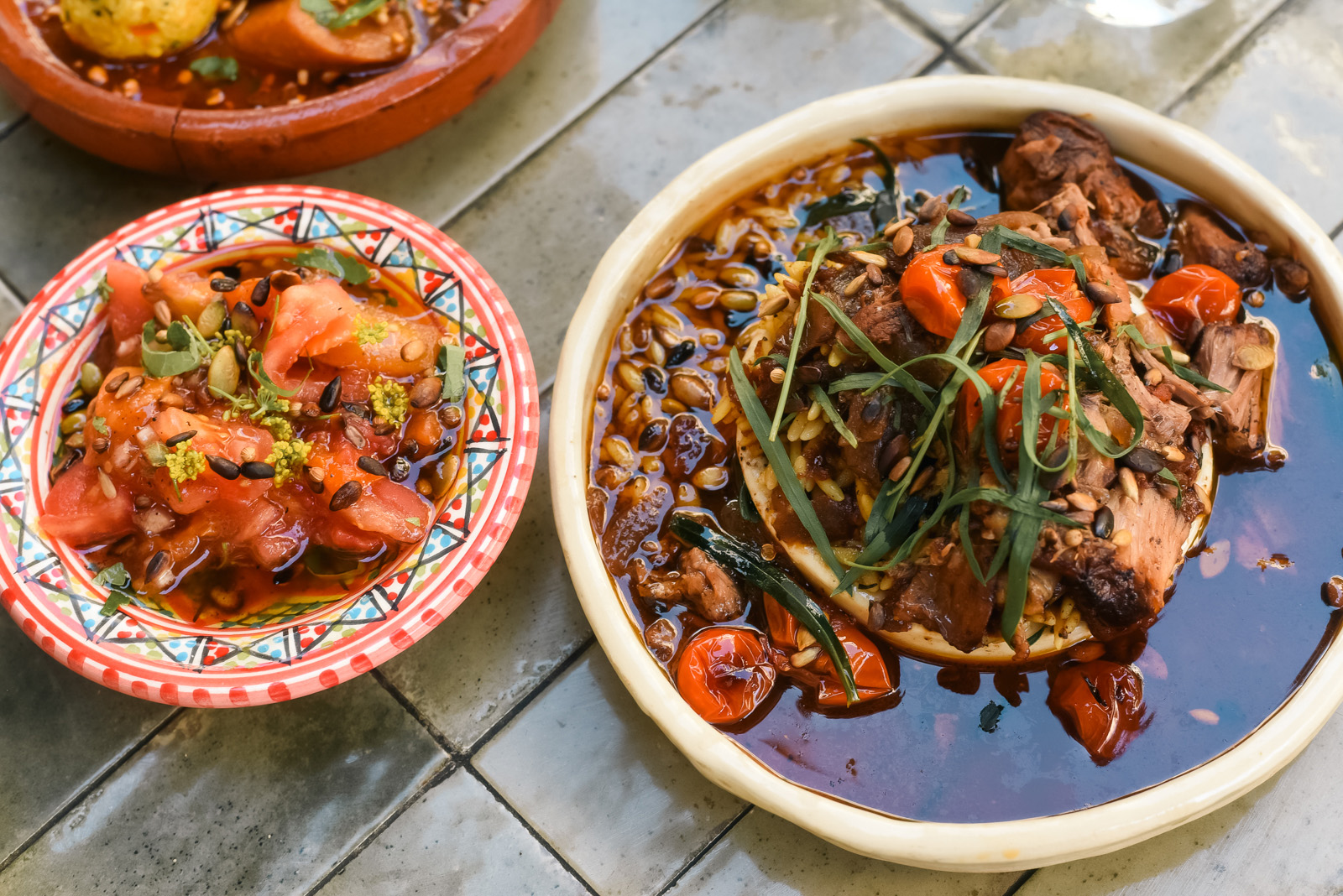 Dishes of the day at Bistrot Baya: leg of Sisteron lamb with orzo and sun-dried tomatoes (right); watermelon and fennel seed salad (left); vegan Amazigh stew (rear left). 