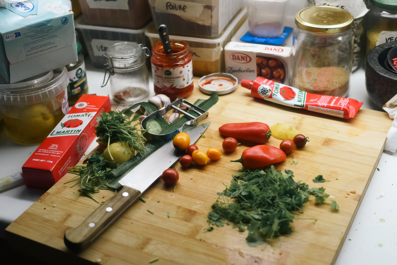 French-Moroccan chef Samia Benazzouz's kitchen as she prepared a fish tagine as part of Soum Soum Kitchen with garlic, coriander, chilli pepper, cherry tomatoes, bell peppers, tomato paste, fresh lemon, harissa, cumin, ground coriander and more.
