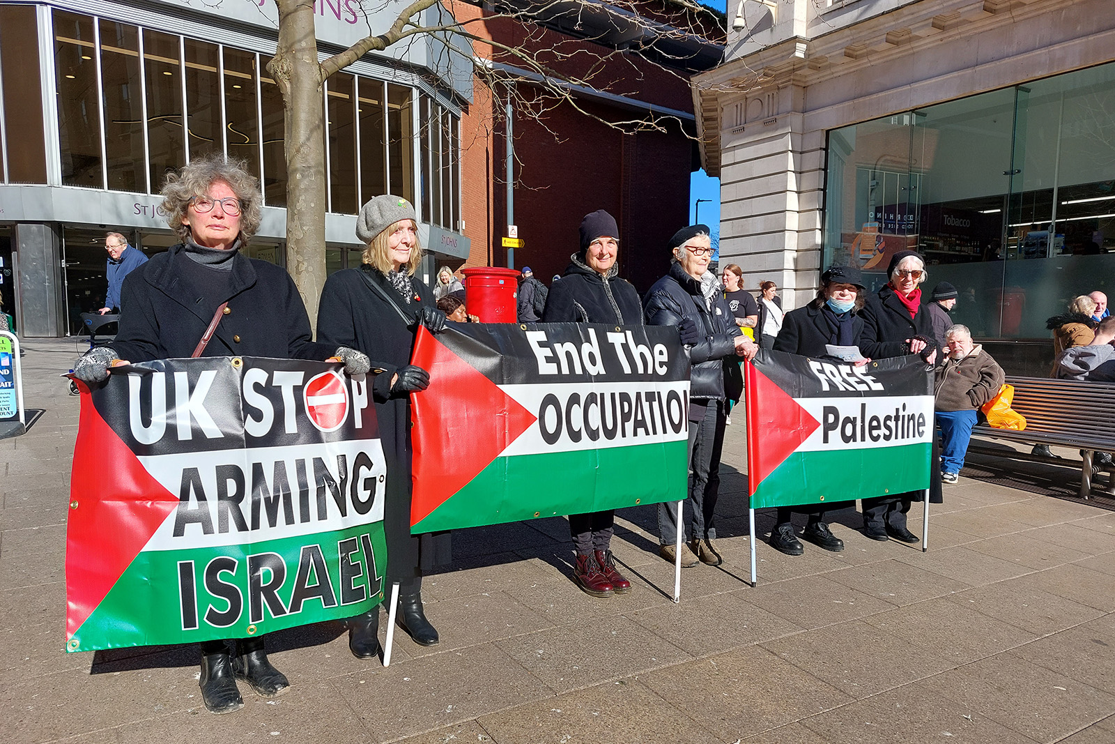 Still from 'The Loud Silence' by Juman Quenis. People holding Palestinian flags at a protest. 