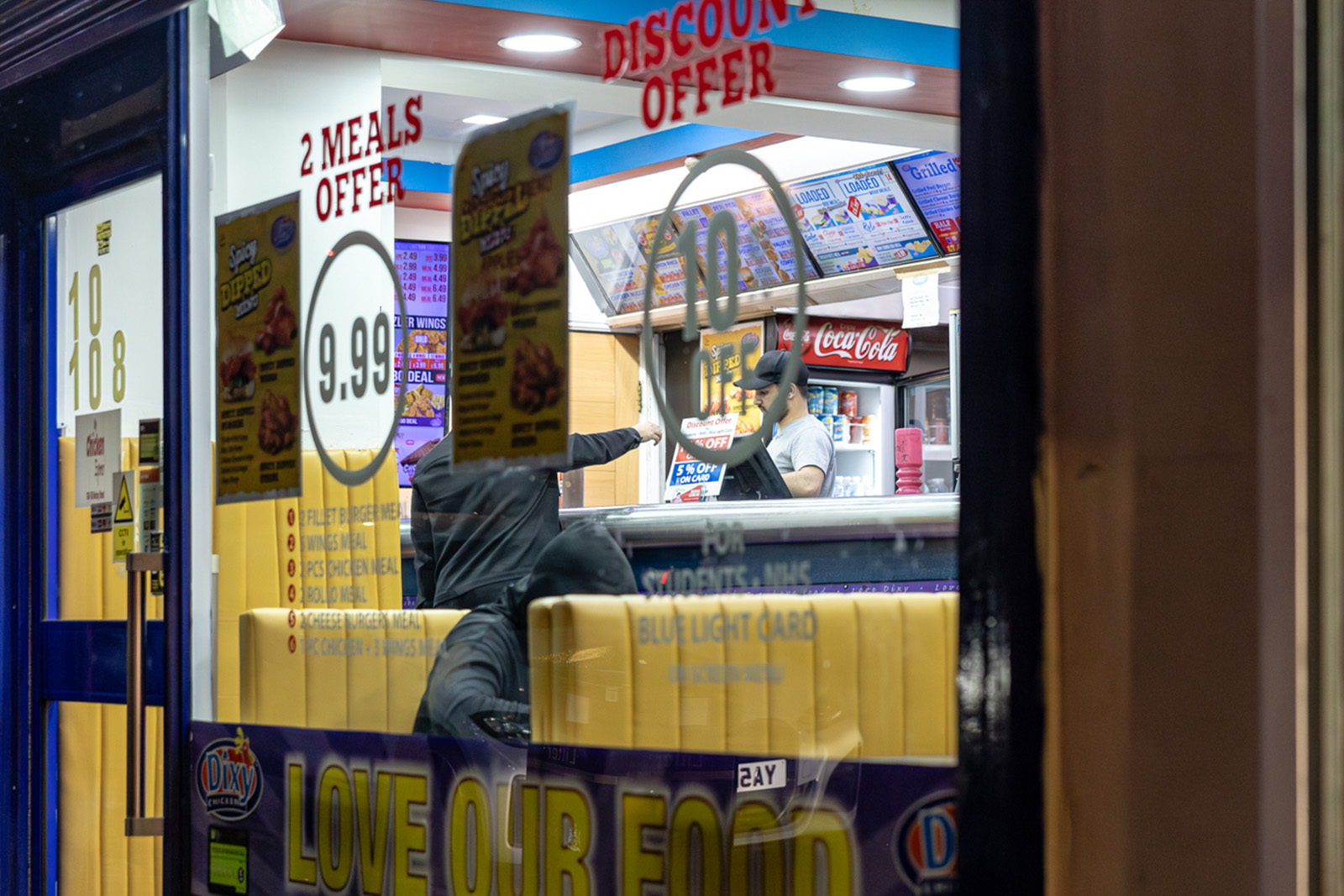 Meal deals and discounts advertised in a takeaways window on Morley Street, Bradford