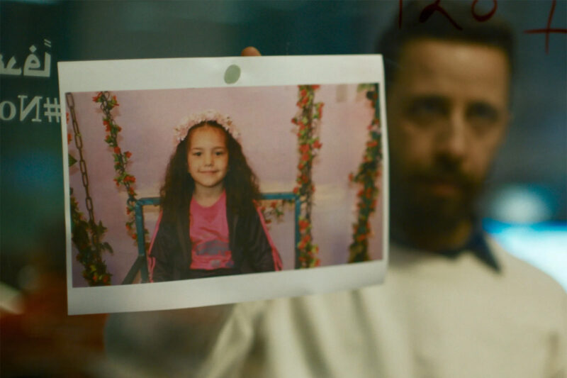 Motaz Malhees, who plays an emergency responder in The Voice of Hind Rajab, holding an image of the girl in a scene from the film