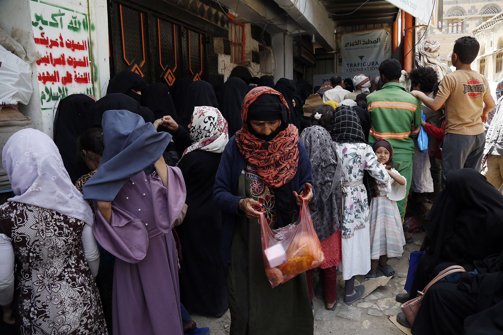 People queuing outside a charity kitchen in Sana'a, the capital of Yemen, which has been devastated by more than a decade of civil war