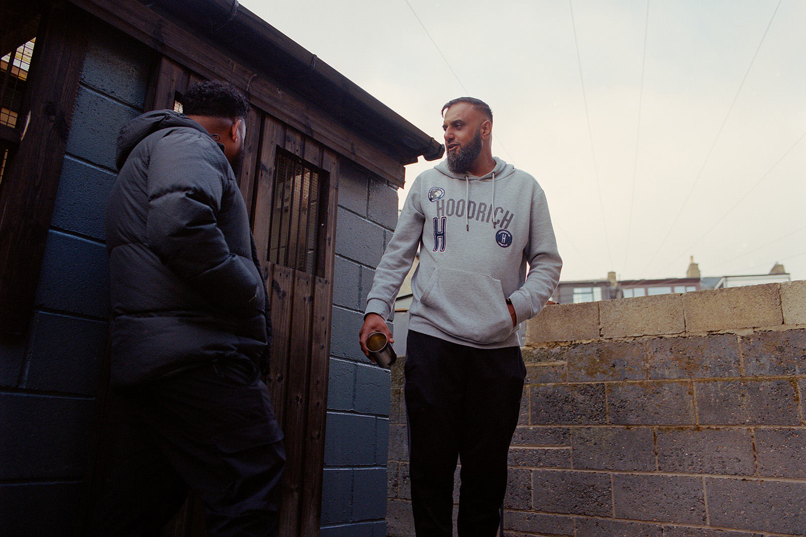 Shahid Miah and Arif Hussain relax near the coop in Hussain’s garden.