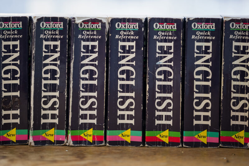 A stock image of a row of Oxford English dictionaries in a school classroom