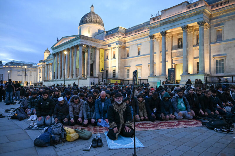 A photograph of people performing prayers at a Ramadan Tent Project Open Iftar event in Trafalgar Square, London, on 16 March 2026.