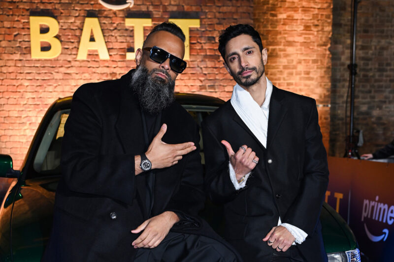 An image of Guz Khan (on the left) and Riz Ahmed sitting on the bonnet of a car at Bait's London premiere at Shoreditch Electric, 24 March 2026.