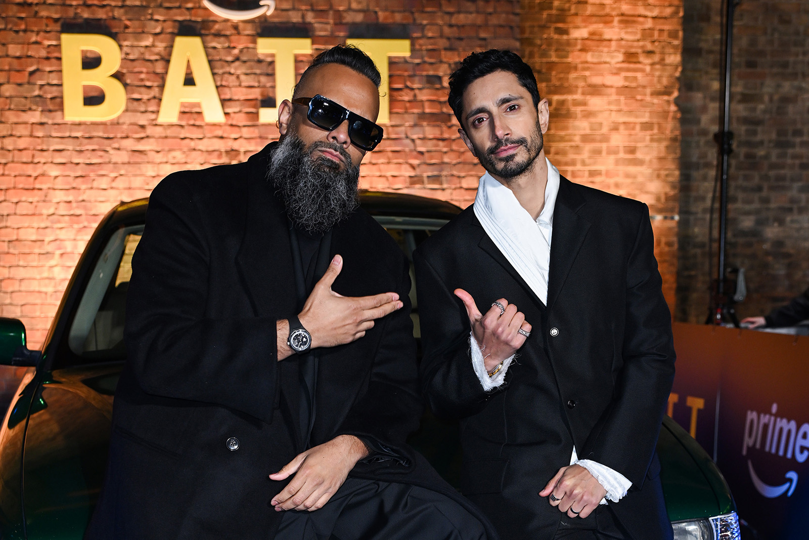 An image of Guz Khan (on the left) and Riz Ahmed sitting on the bonnet of a car at Bait's London premiere at Shoreditch Electric, 24 March 2026.