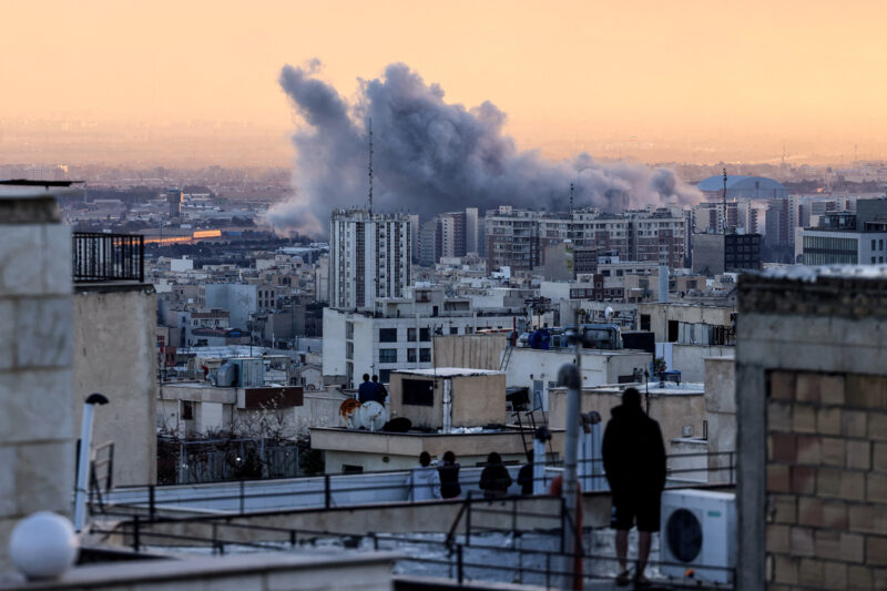A photograph of Tehran residents watching from their roofs as smoke rises from a nearby explosion, as the US/Israeli bombardment of the Iranian capital continued on Tuesday 3 March