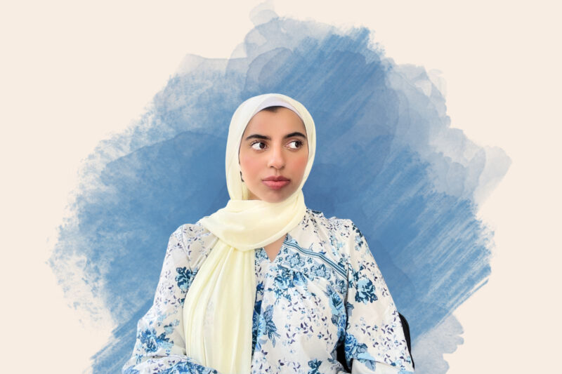 A portrait photograph of fantasy author Sarah Mughal Rana, seated and wearing a pale yellow headscarf