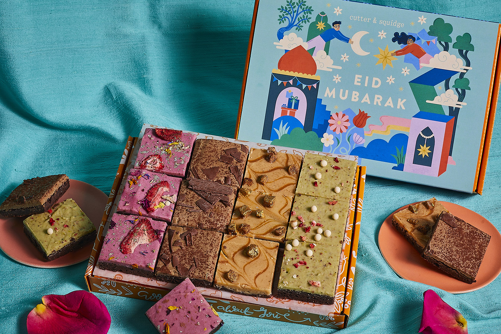 A photograph of a Cutter & Squidge Eid brownie selection box, open to show the sweets inside and with a lid wishing customers 'Eid Mubarak'