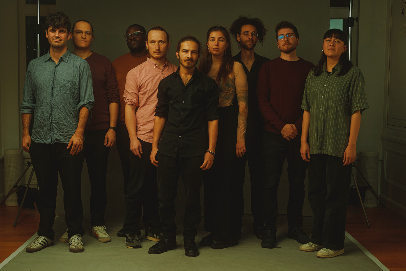 A photo of the Ramzi Hammad & Collective band, with Hammad in the centre of the group of nine