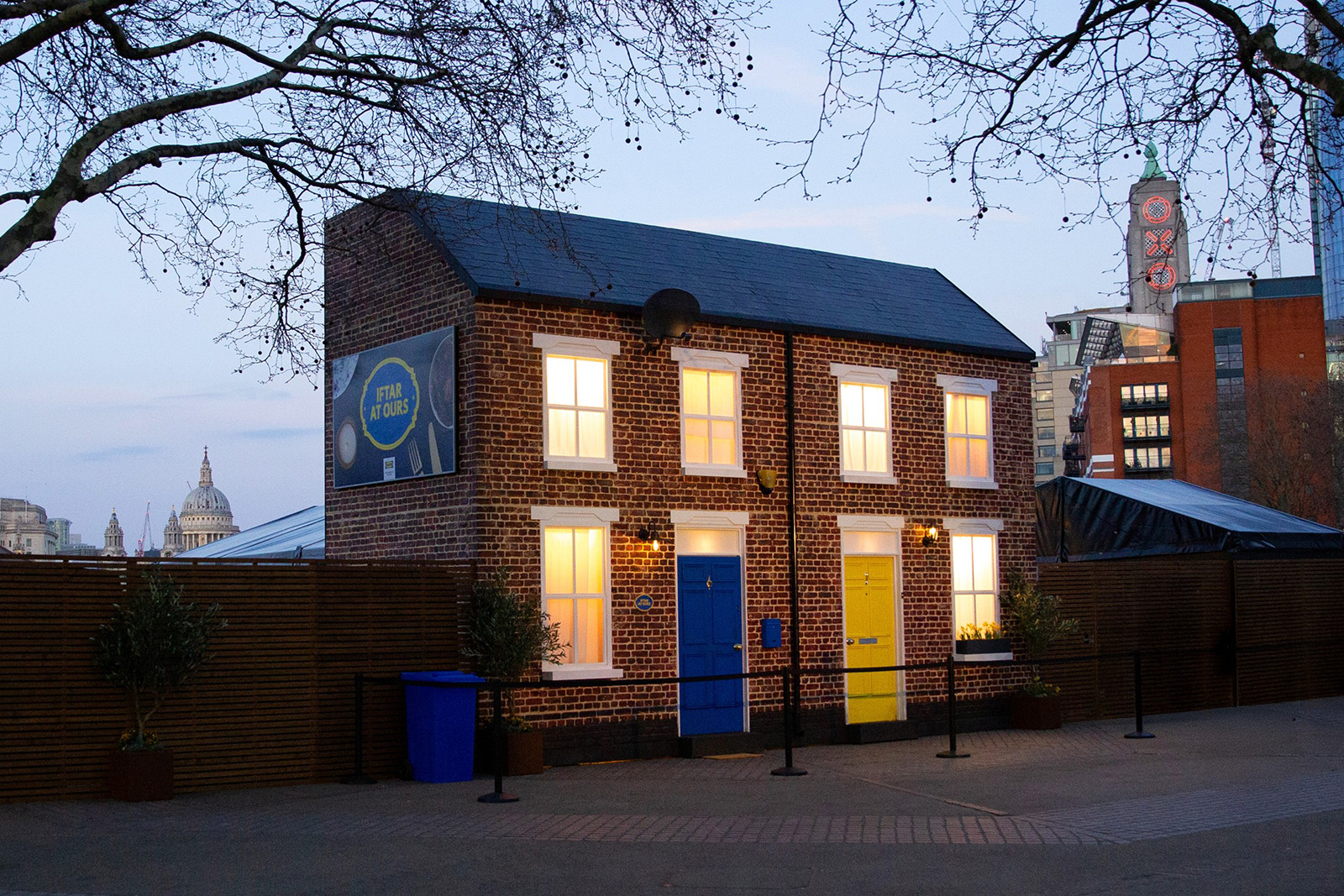 A photograph of the pop-up terraced houses at the centre of Ikea's Iftar At Ours campaign, on London's South Bank, with the Oxo Tower and St Paul's Cathedral visible in the background