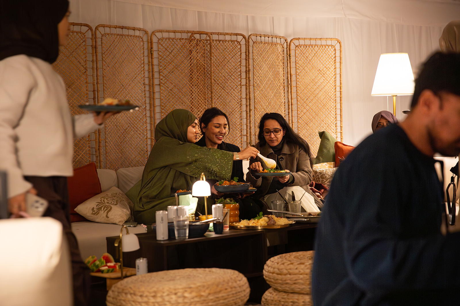 A photograph of the interior of Ikea's Iftar At Ours pop up, featuring three women sitting together and sharing a meal to break fast