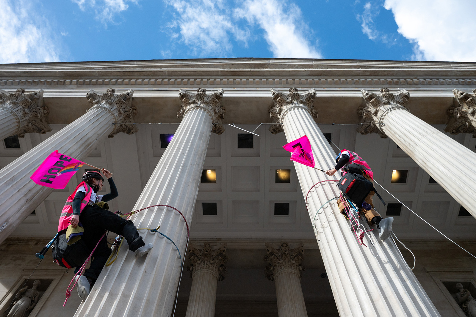 Two protesters climb the columns of the National Gallery in Trafalgar Square with flags reading 'Hope' and 'Love' during the Together Alliance rally on Saturday 28 March. They were later arrested.