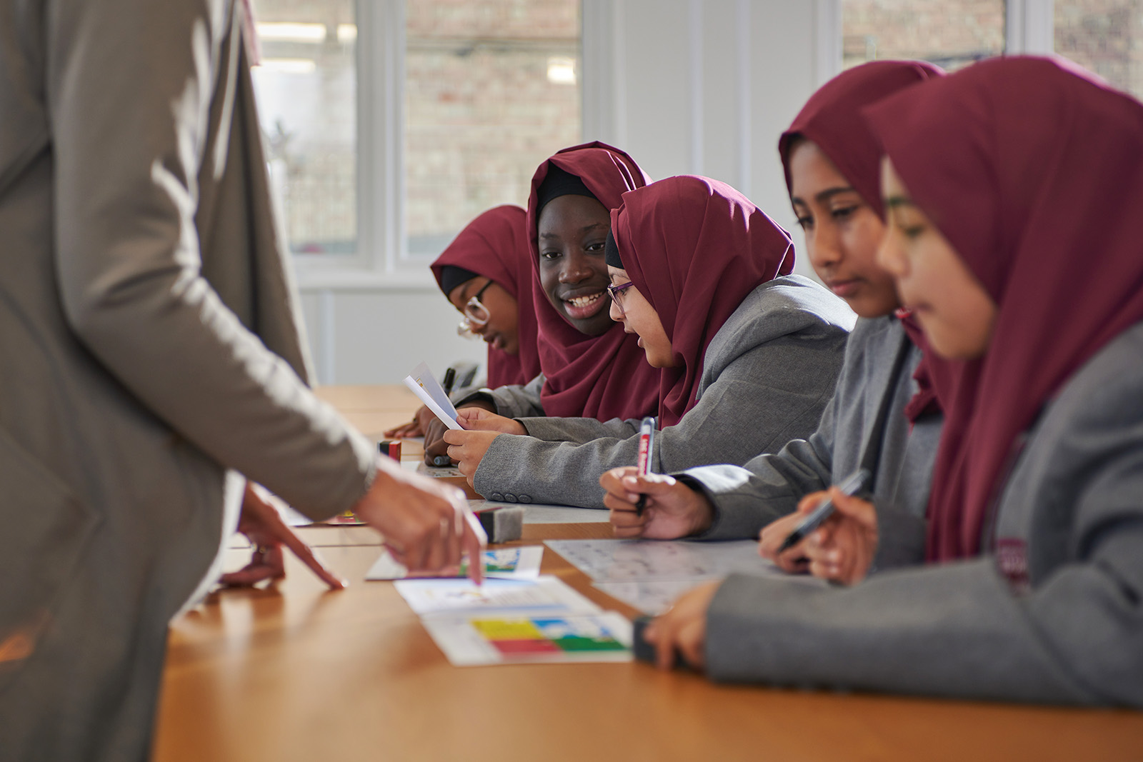A photograph of students working in a classroom at Madani Girls School