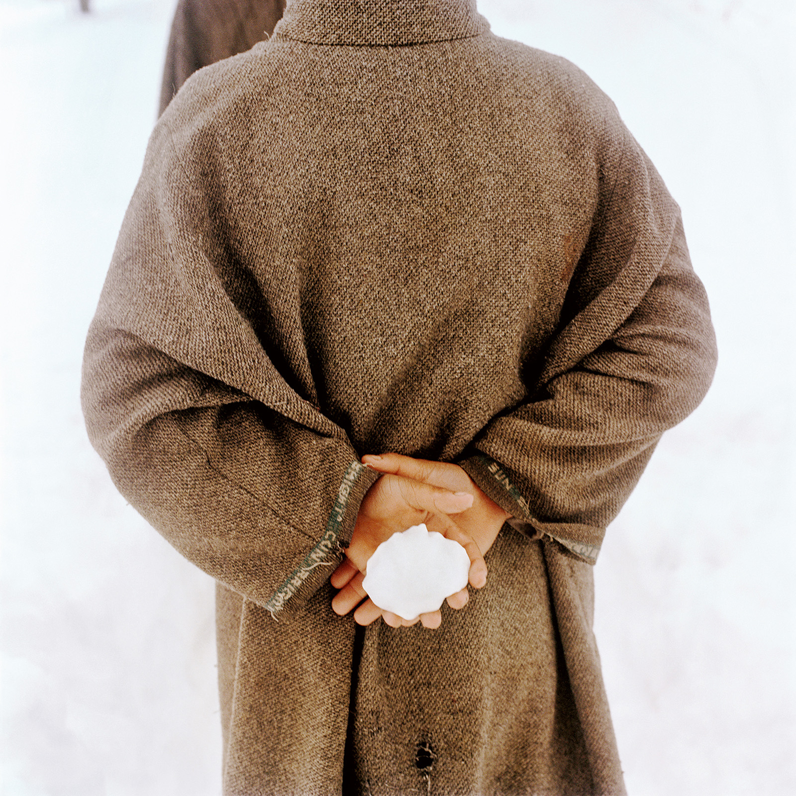Sohrab Hura, Snow. Photograph of back of person holding a snow ball. 