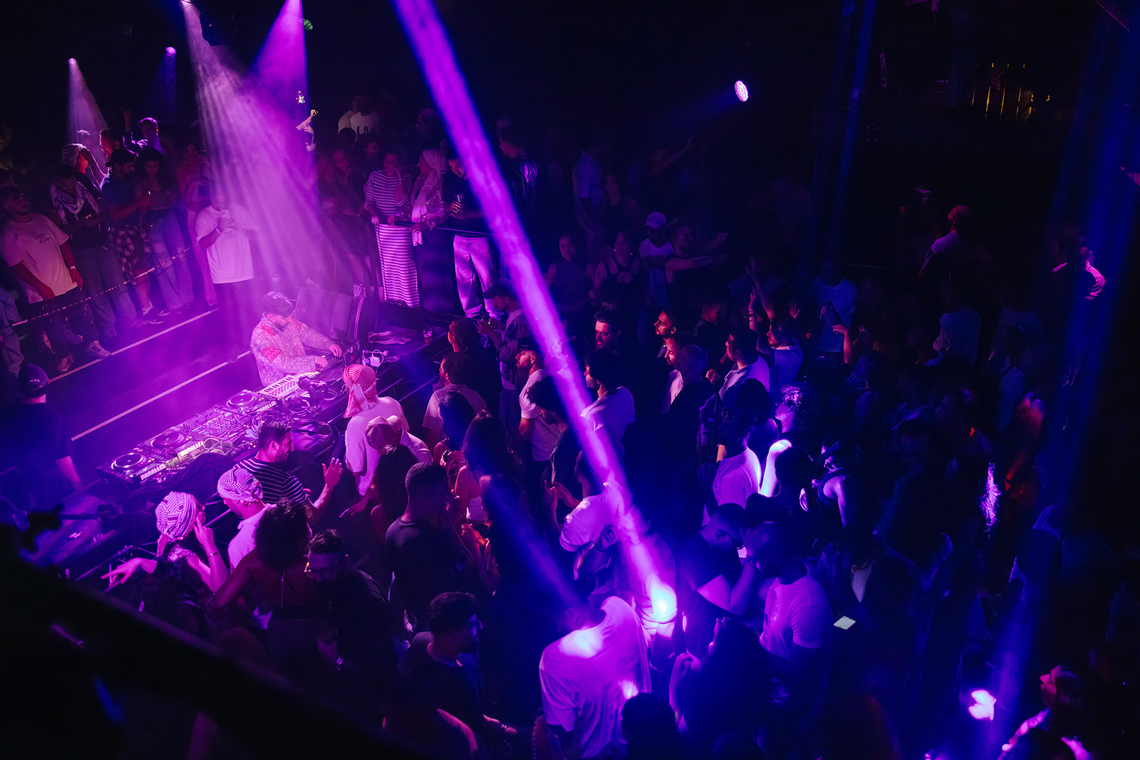 A photograph of a DJ and a crowded dance floor at a Third Culture Club night, autumn 2025