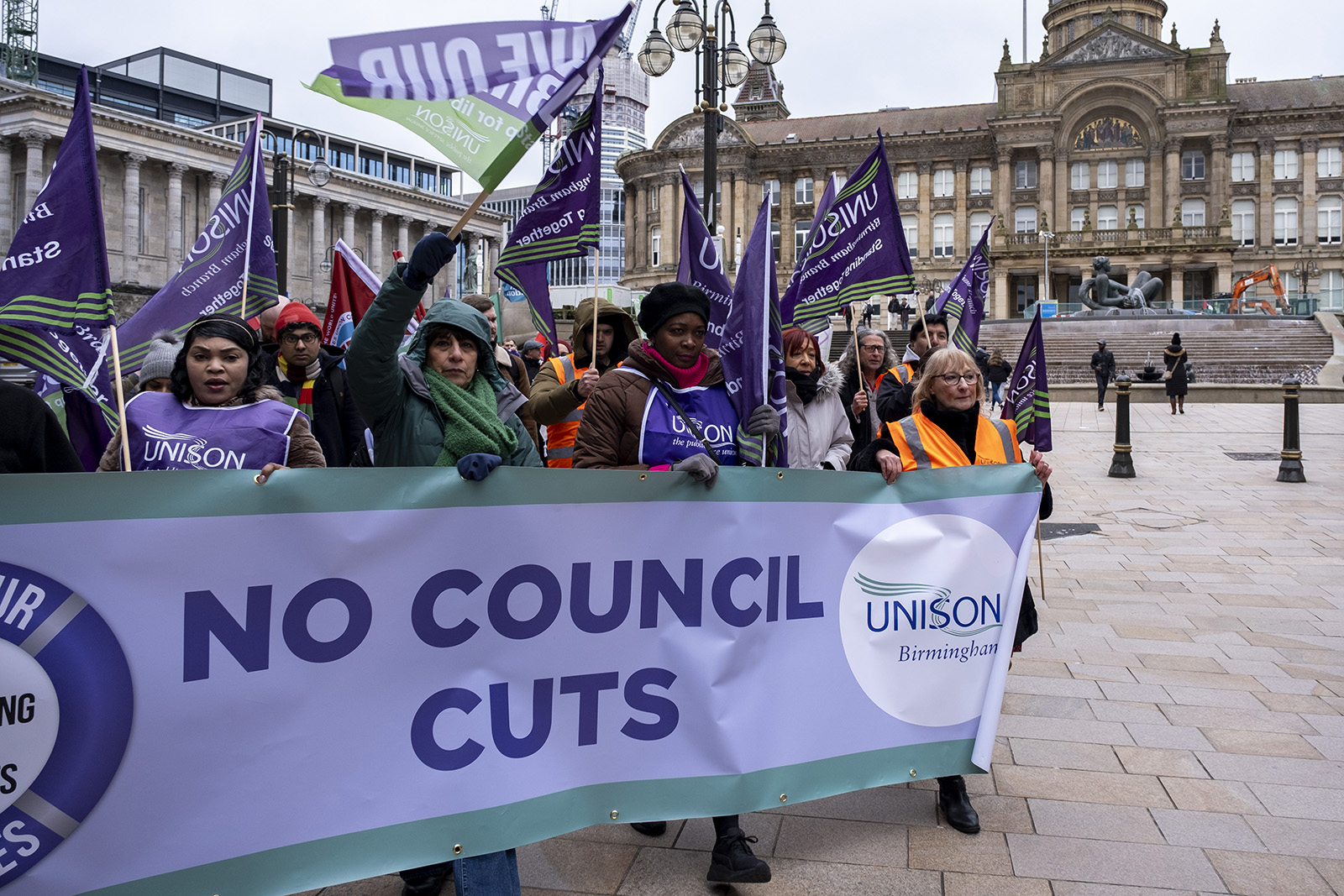 Protesters behind a banner reading 'no council cuts'