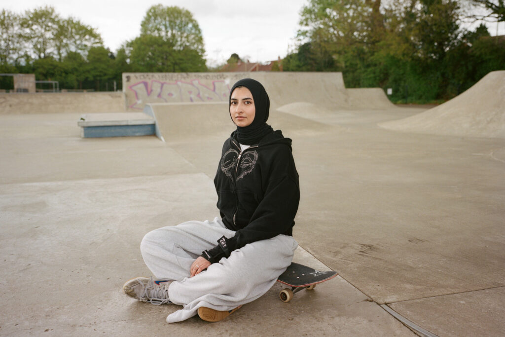 Huda Kherati, photographed sitting on her board in a skate park