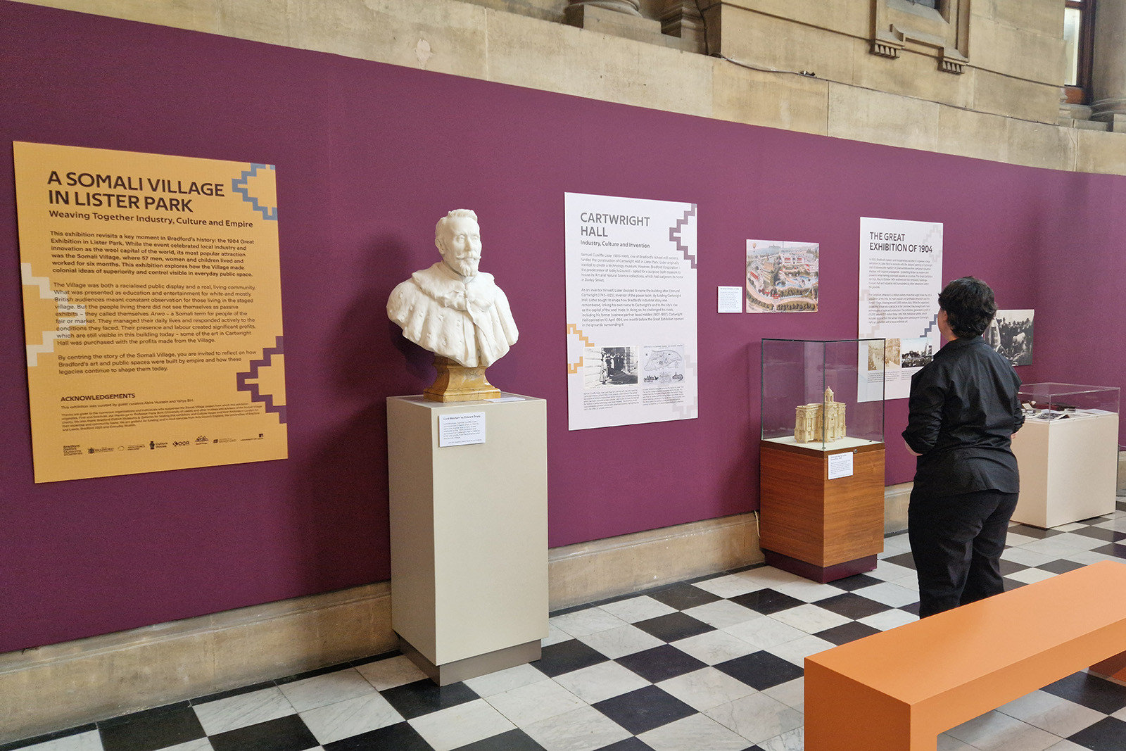 A photograph of part of the A Somali Village in Lister Park exhibition, showing artifacts including a bust of a man's upper body on a plinth 