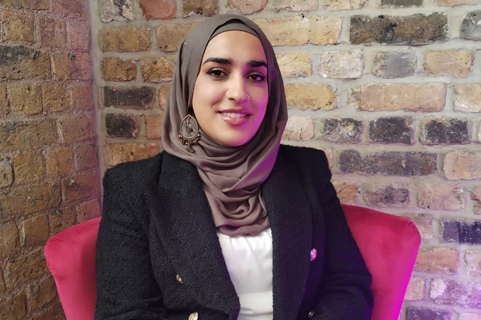 A portrait photograph of a seated Ayesha Aslam, London-based couples counsellor and founder of Sakoon