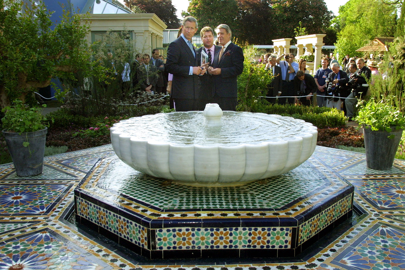 Prince Charles, The Prince Of Wales, looks at the fountain feature in "carpet garden" exhibit at The Chelsea Flower Show in London 21 May 2001. Prince Charles, who has a long-standing interest in Islamic decorative arts, had the inspiration from carpet designs. 
 AFP PHOTO: Adrian DENNIS / WPA POOL (Photo by ADRIAN DENNIS / AFP) (Photo by ADRIAN DENNIS/AFP via Getty Images)