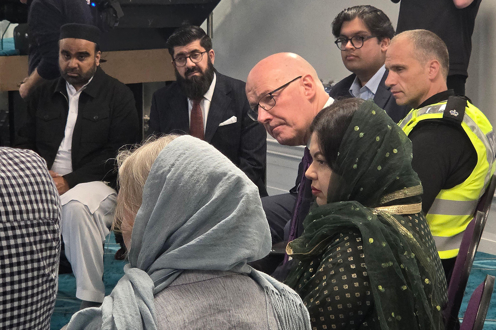 Scottish first minister John Swinney and police chief Neil Wilson speak to people standing in a partial circle in the wake of the Edinburgh attacks