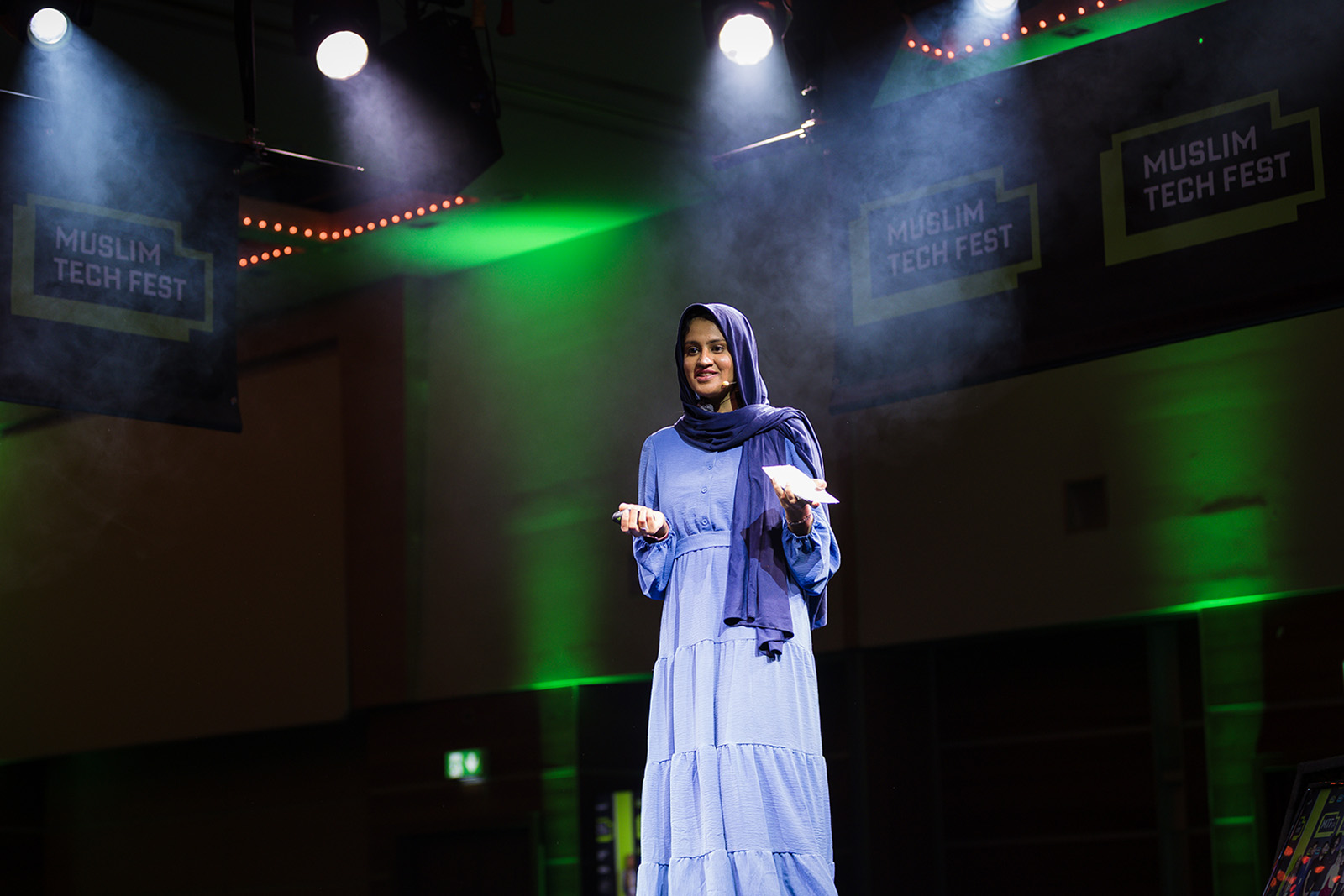 A photograph of Muslim Tech Fest co-founder Arfah Farooq speaking on stage at the 2026 event