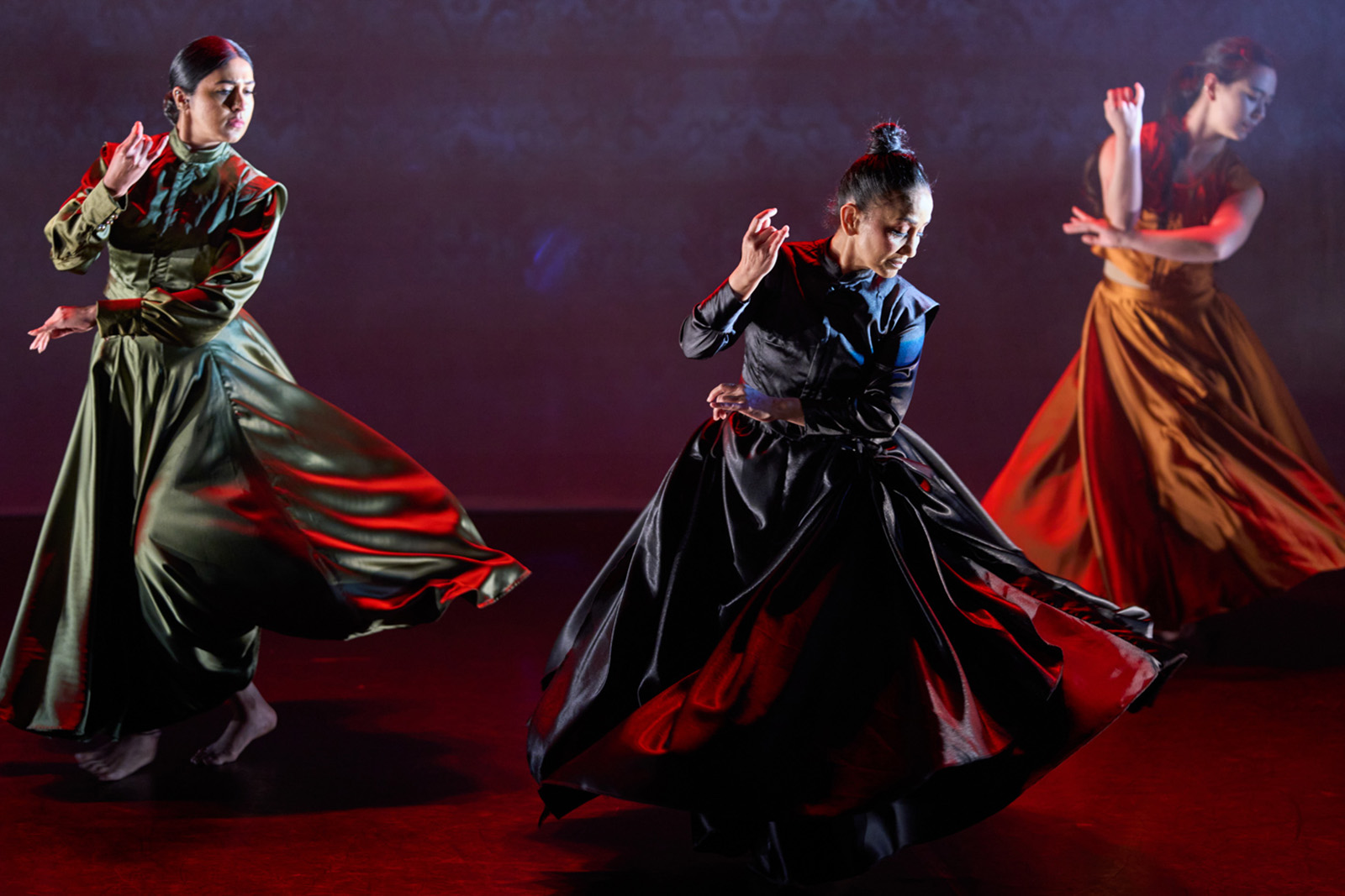 A photograph of three female kathak dancers performing on stage in a production of Bibi Rukiya's Reckless Daughter, at The Place theatre in London