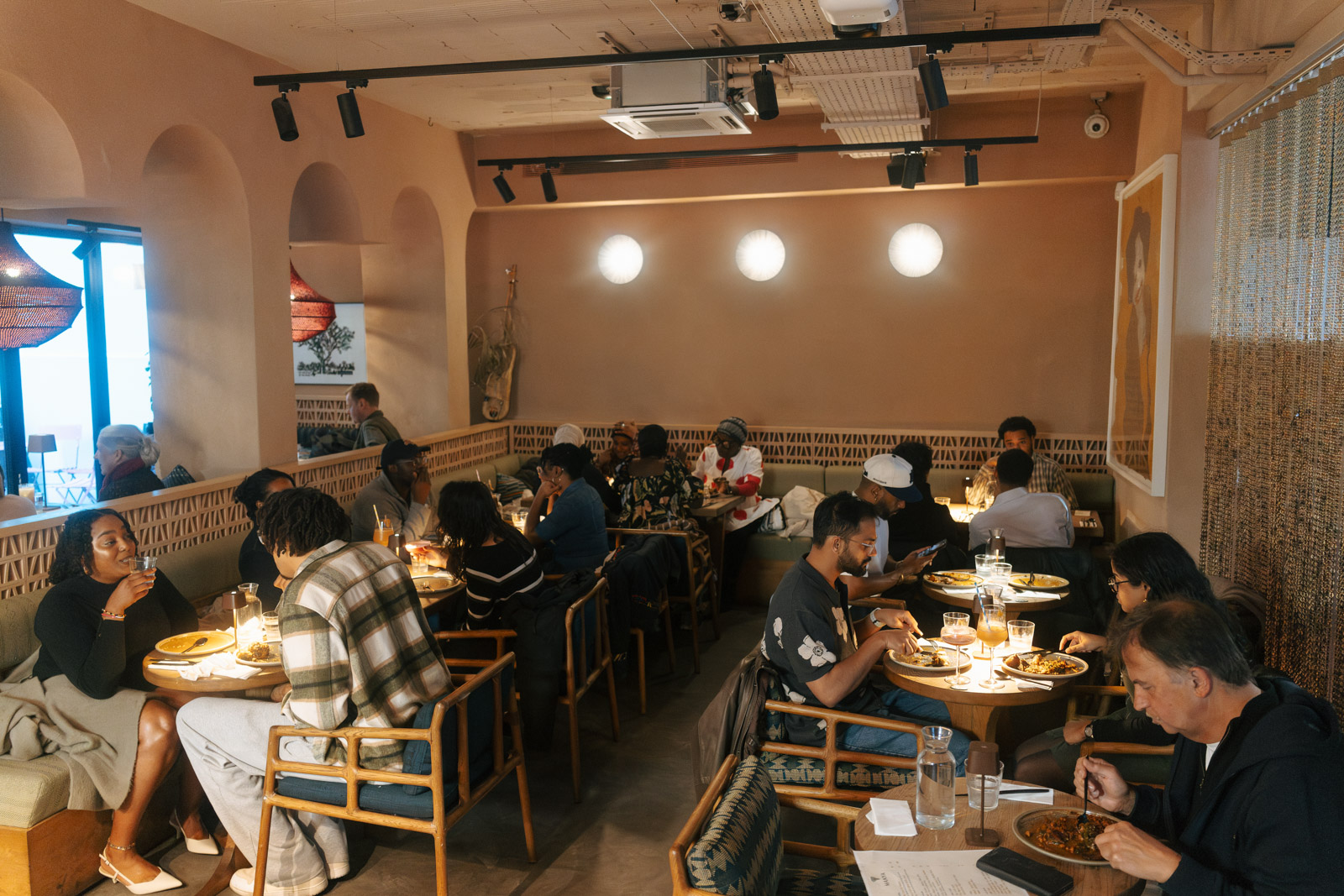 A photograph showing Little Baobab's space in the Africa Centre, with every table full of diners