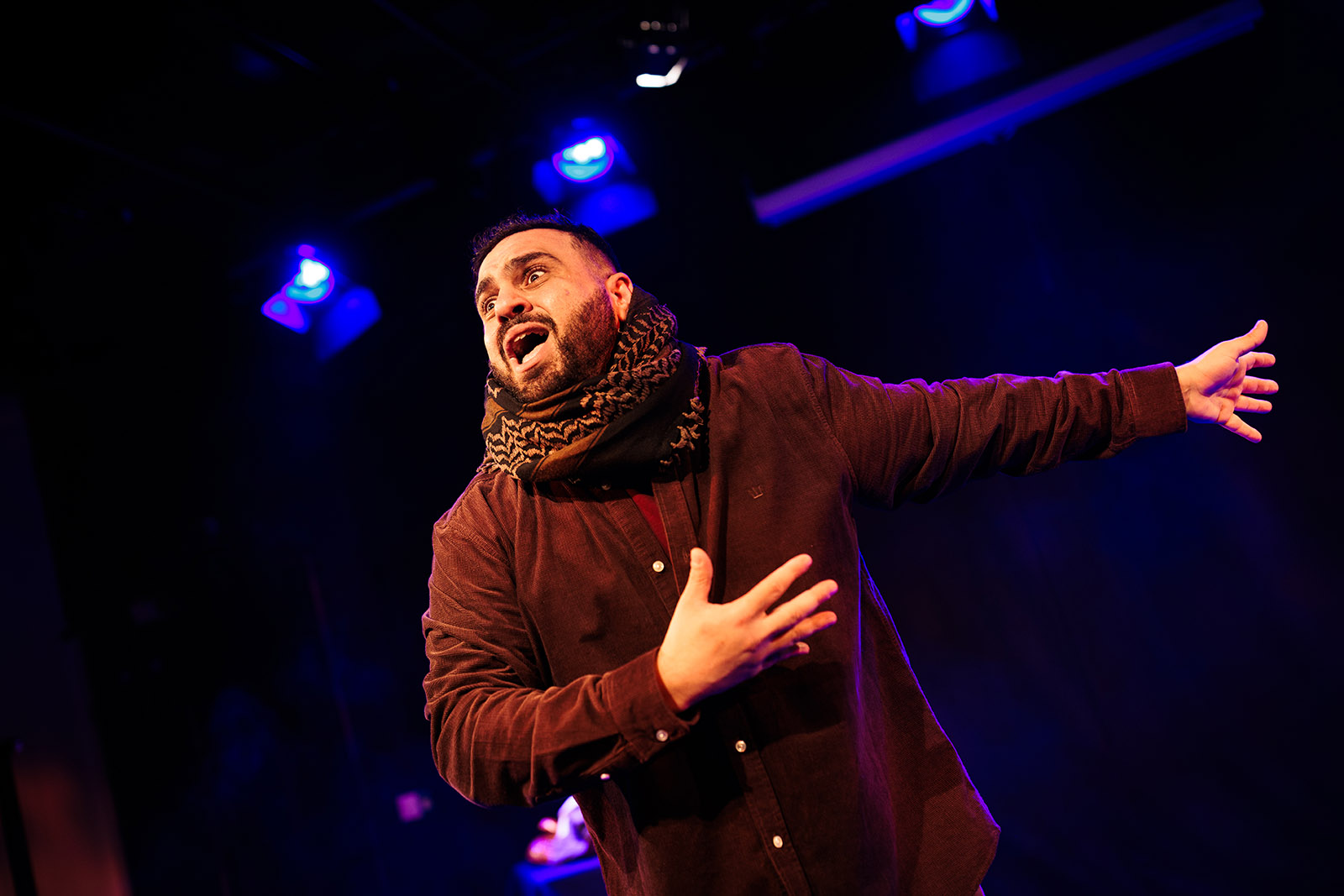 A photograph of Alaa Shehada on stage performing his one-man play The Horse of Jenin