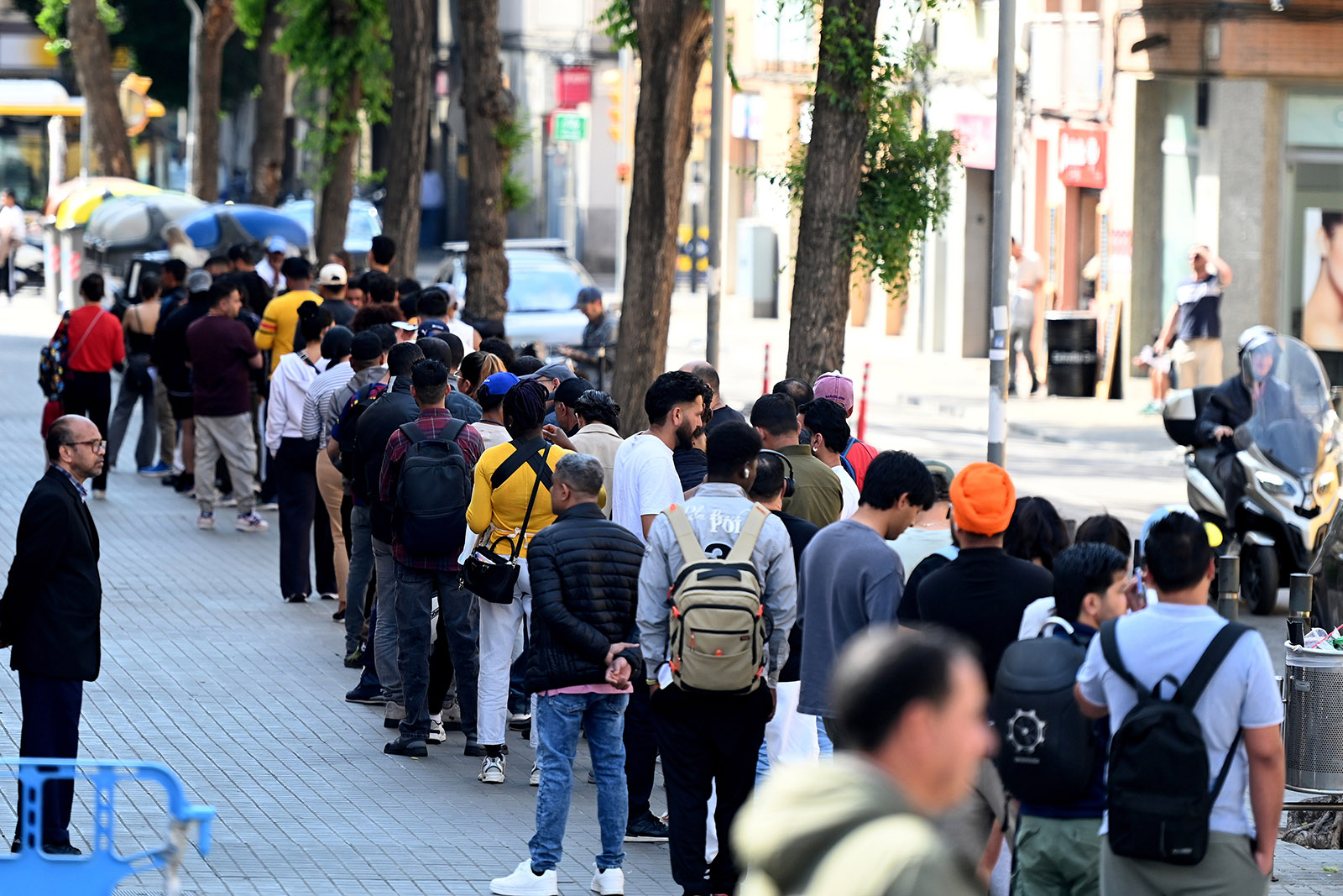 A photograph of a queue of people in a street in Barcelona seeking to legalise their immigration status under the Spanish government's regularisation scheme, taken in April 2026