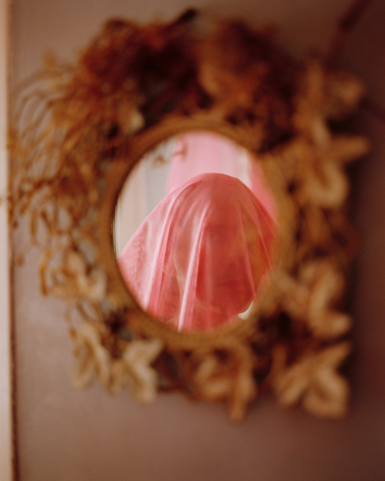 A photograph, titled A separate universe, of a reflection in a round mirror of a person wearing a veil. From Camille Farrah Lenain’s monograph Made Of Smokeless Fire