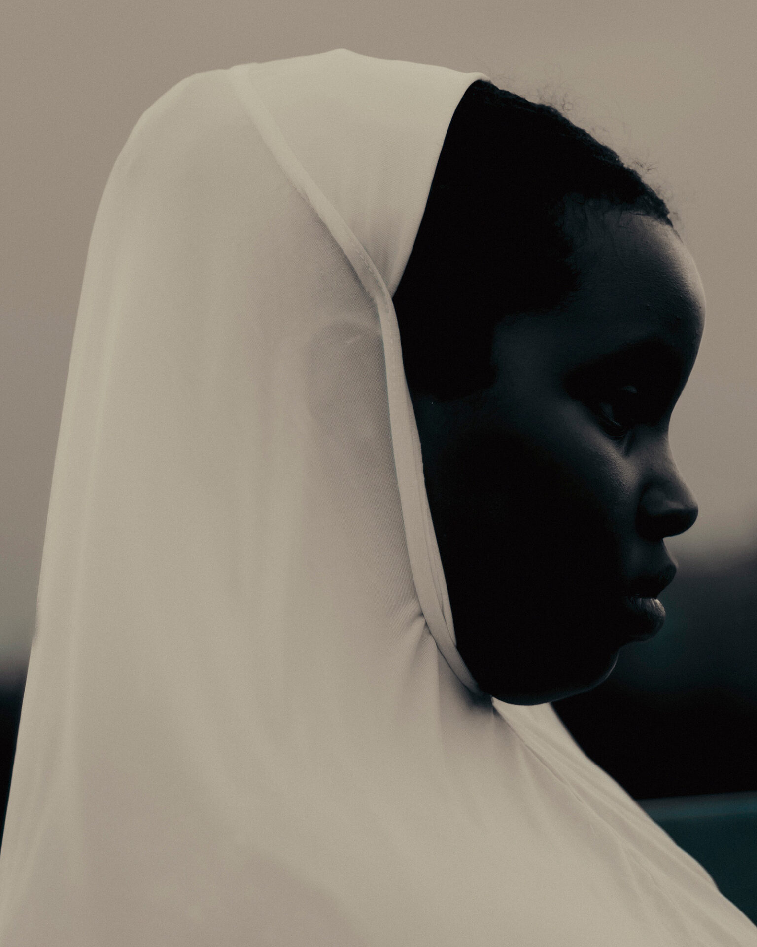 Photographer Ikram Abdulkadir's black and white portrait image of a woman, shot in profile from the shoulders up