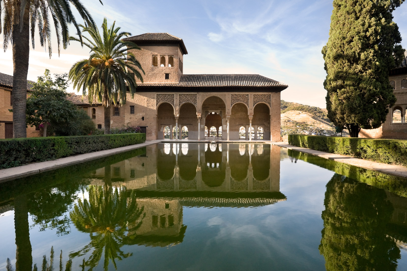 A view of an ancient palace at sunset at the Alhambra in Spain. A perfect mirrored reflection.