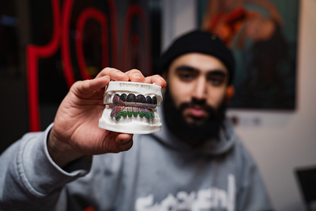 Studio Bite owner Zaid Hassan holding dental grills