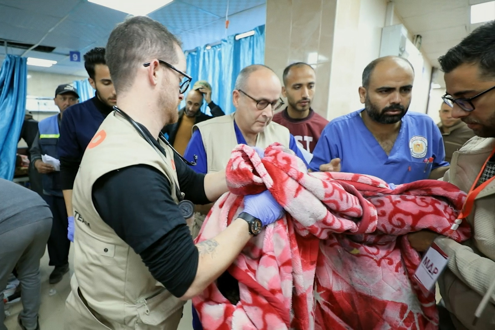 A still image from Daniele Rugo's documentary Life Support, showing medical workers in a hospital with a blood-stained blanket
