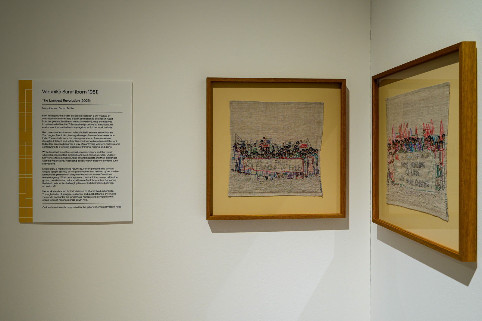 A photograph of part of the (Un)Layering the Future Past of South Asia exhibition at Bradford's Cartwright Hall Art Gallery, featuring two embroidered works by Indian artist Varunika Saraf