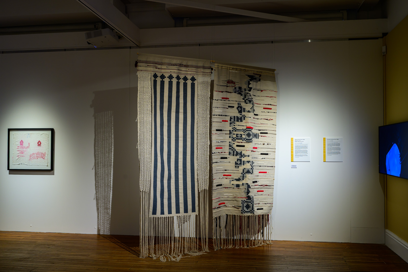 A photograph of part of the (Un)Layering the Future Past of South Asia exhibition at Bradford's Cartwright Hall Art Gallery, featuring textile works hanging from the ceiling