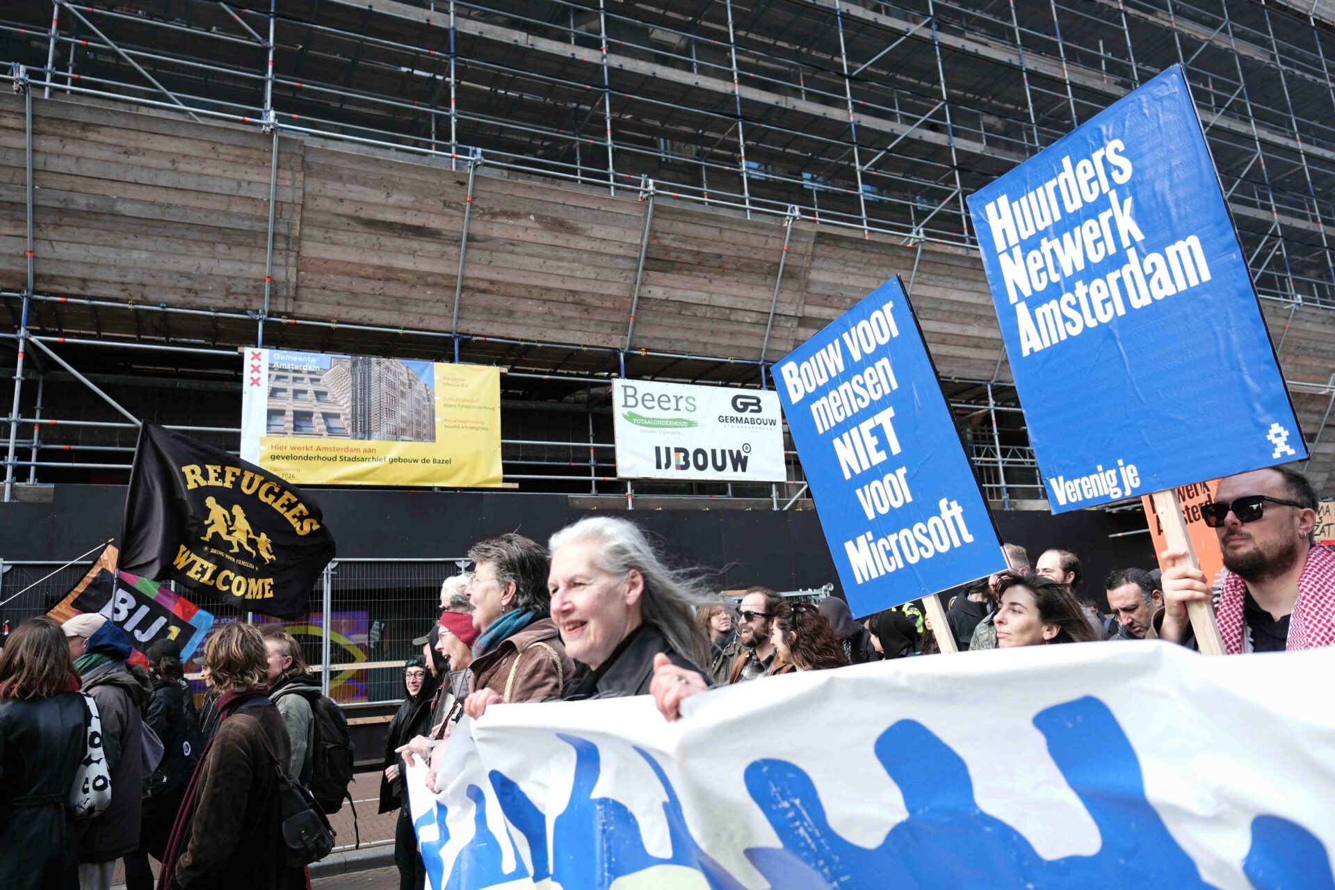 A photograph of protesters marching with placards and banners in Amsterdam on 1 March 2026, during a demonstration against the lack of affordable housing in the city